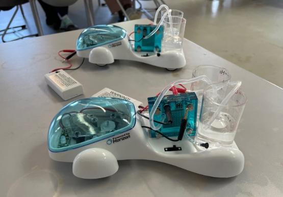 two small plastic model cars on a table in a lab