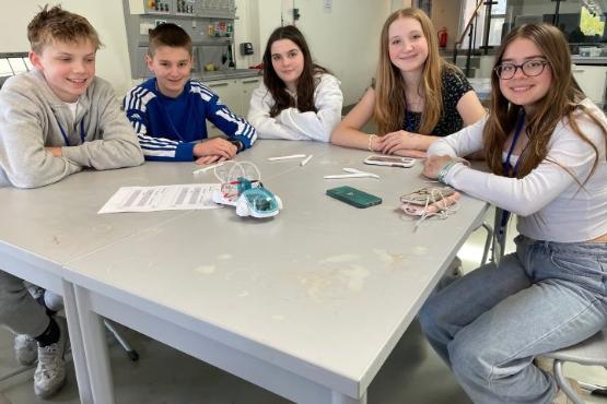 five students sat around a table in a science lab