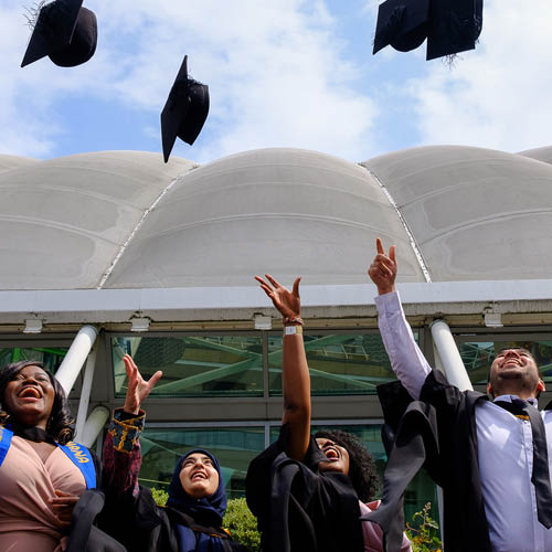 Students throwing their mortarboards in the air on their graduation day