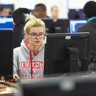 A student on a desktop computer in one of our on-campus 'cluster' rooms