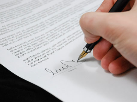 Paper document being signed with a fountain pen
