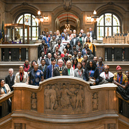 Staff and international students posing together in Bradford city hall.