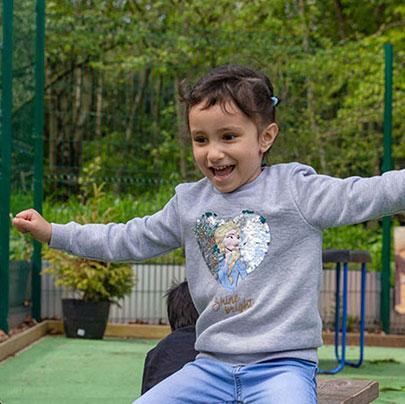 Child smiling on seesaw