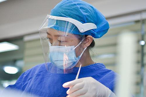 Nurse in visor and gloves (PPE)