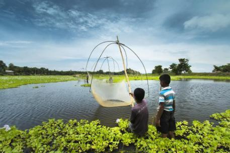 Two boys fishing in a lake in India