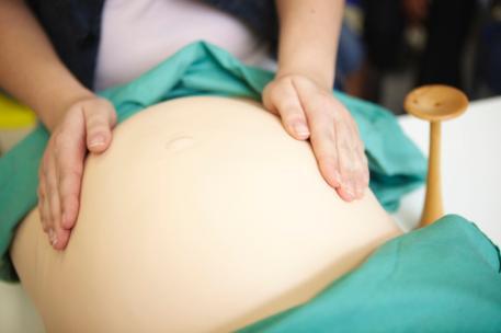 A Midwifery student examining a dummy