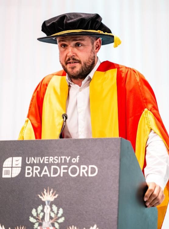 a person stands up at podium to give speech at graduation ceremony a person stands up at podium to give speech at graduation ceremony