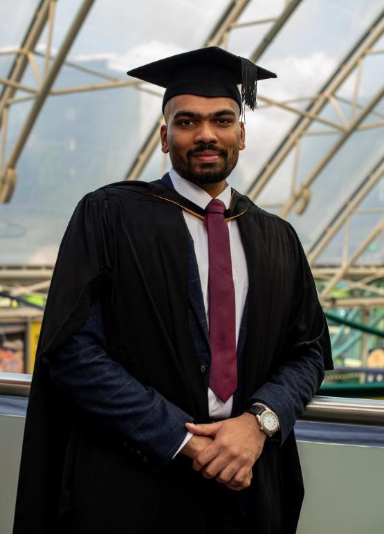 A student stood up wearing graduation gown at the university A student stood up wearing graduation gown at the university