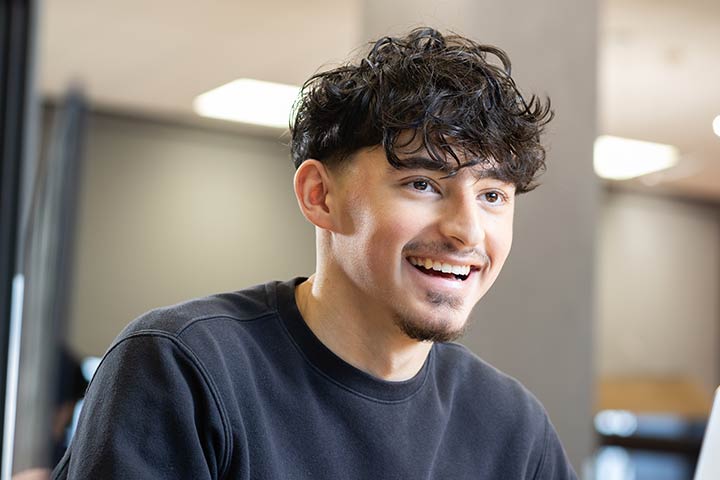 A student smiling and looking away from the camera.