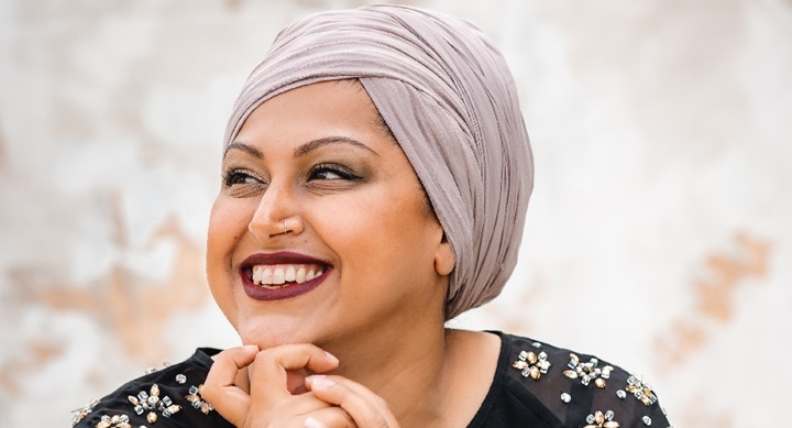close up of a person smiling and wearing a headdress