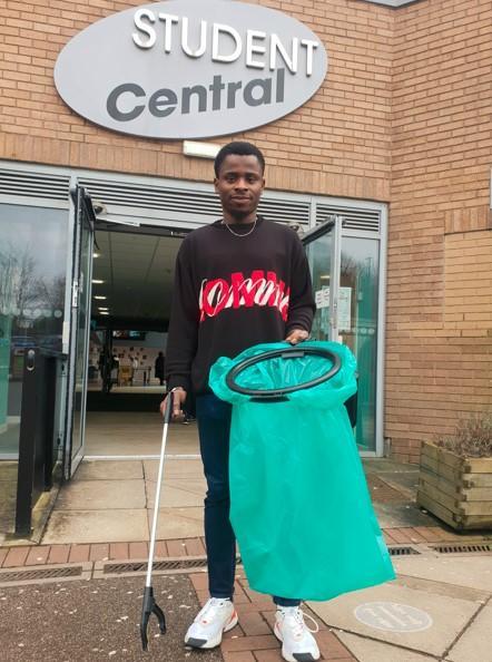 Sabbatical officer Rotimi Olorunfemi picking up litter Sabbatical officer Rotimi Olorunfemi picking up litter