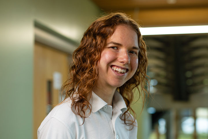 A student wearing a physiotherapy uniform smiling at the camera