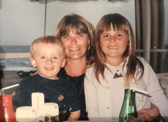 One adult and two children smiling One adult and two children smiling