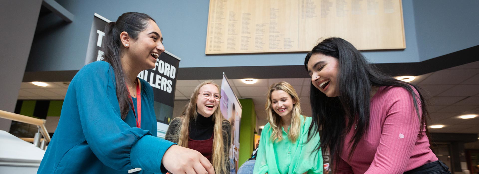 A group of student playing table top football and laughing.