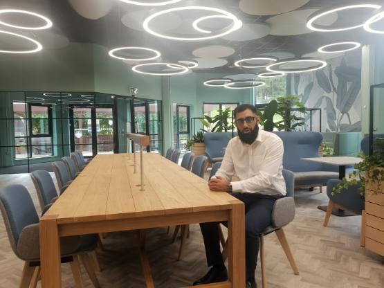 A university staff member sat at a table in a new-look university students' union area A university staff member sat at a table in a new-look university students' union area