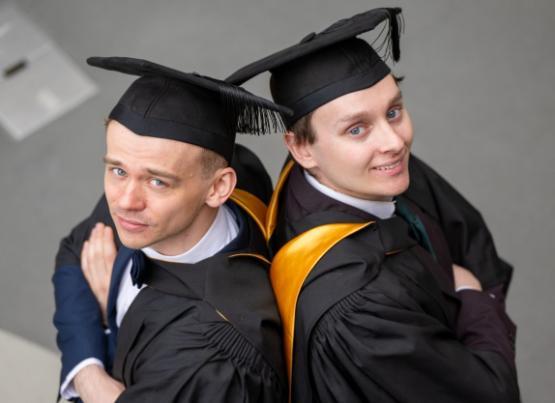 Two graduands looking into camera Two graduands looking into camera