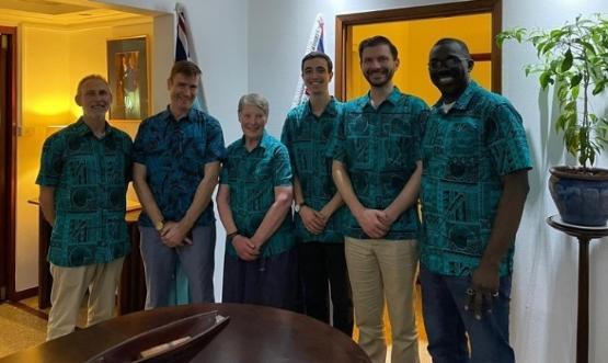 five people wearing the same Hawaiian style shirt stand next to each other five people wearing the same Hawaiian style shirt stand next to each other