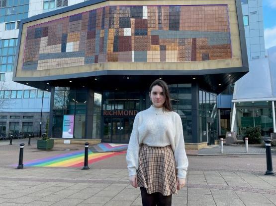 Student stood outside main university building Student stood outside main university building