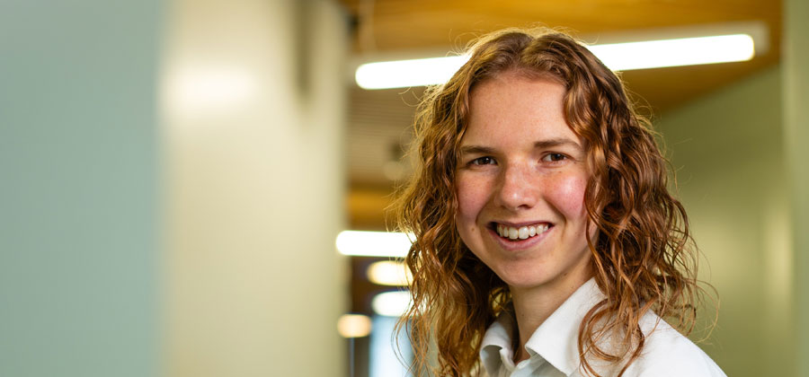 A student wearing a physiotherapy uniform smiling at the camera