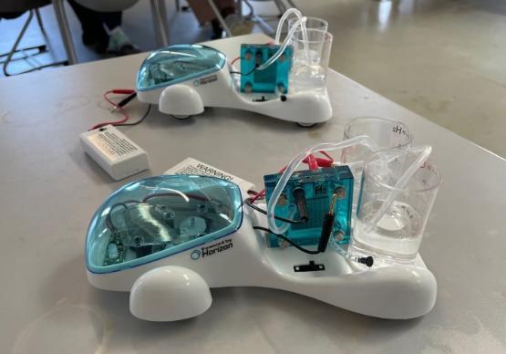 two small plastic model cars on a table in a lab two small plastic model cars on a table in a lab