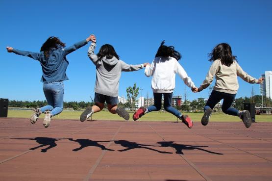 Four children jumping in the air in a playground