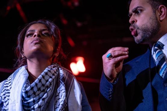 A person wearing a scarf around their neck holds their head up in defiance as a person next to them speak to them sternly A person wearing a scarf around their neck holds their head up in defiance as a person next to them speak to them sternly