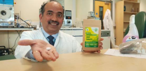 Professor Anant Paradkar holding an effervescent tablet coated in co-crystal