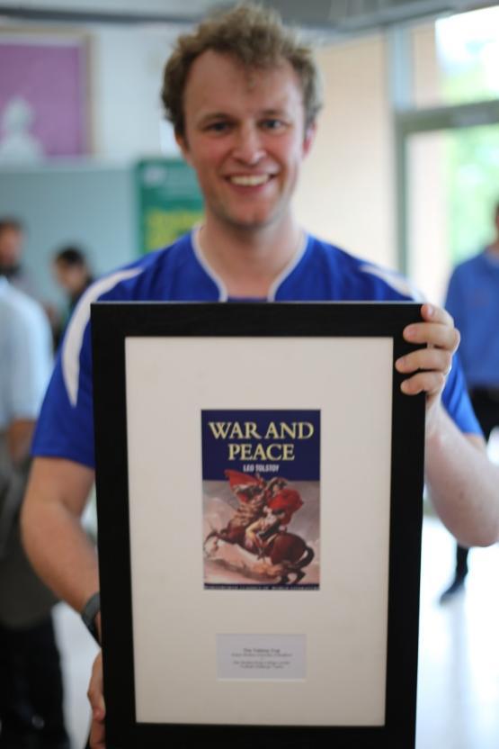 A football player in kit holds a framed trophy in front of them A football player in kit holds a framed trophy in front of them