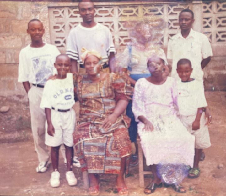 Two rows of people including children pose for a group photo outside
