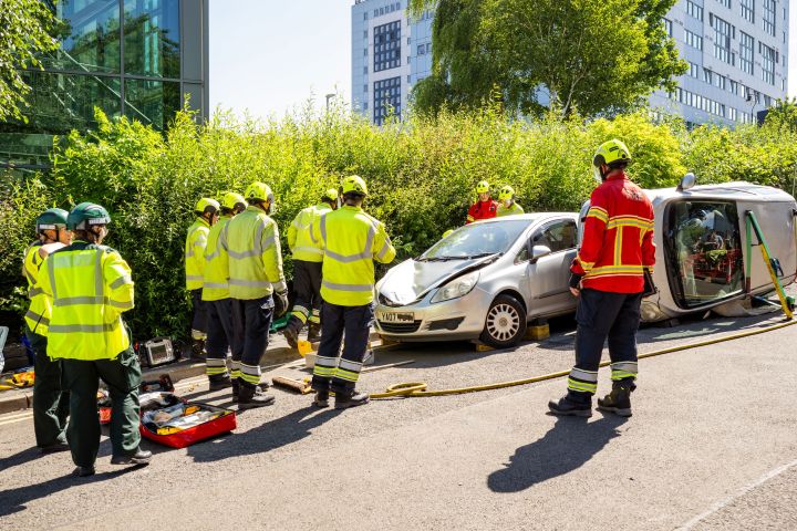 A few uniformed paramedics near a crashed car A few uniformed paramedics near a crashed car