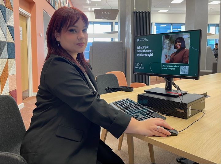 A student sat at a desk uses a computer A student sat at a desk uses a computer