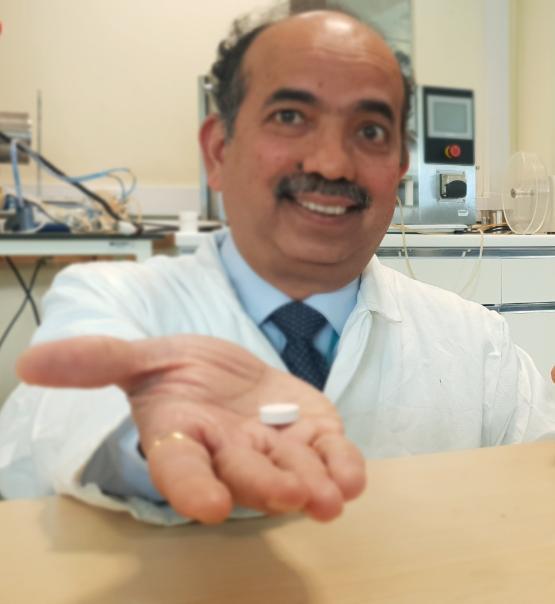 Professor Anant Paradkar holding an effervescent tablet coated in co-crystal Professor Anant Paradkar holding an effervescent tablet coated in co-crystal