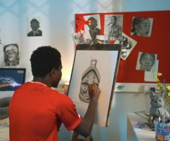 a person wearing a red T-shirt sat down drawing a picture a person wearing a red T-shirt sat down drawing a picture