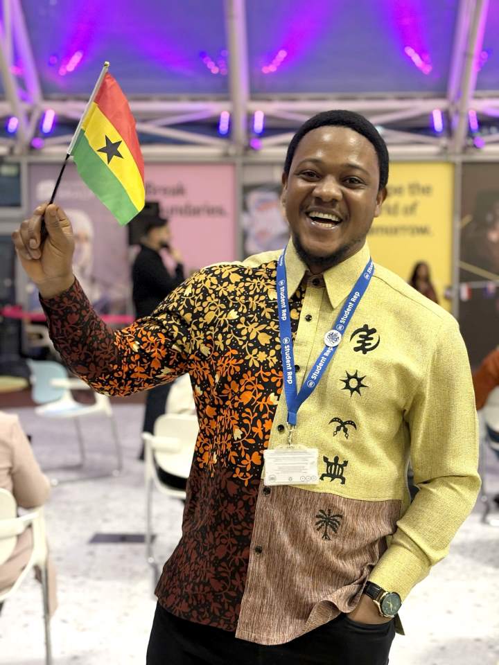 A student smiles as they wave a small Ghana flag A student smiles as they wave a small Ghana flag