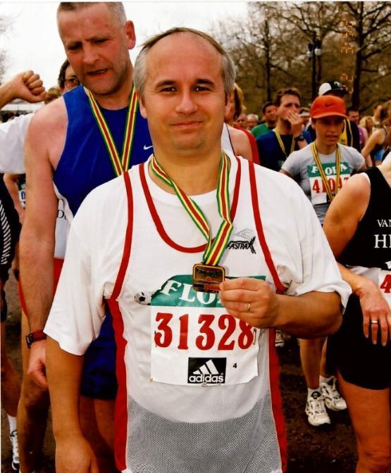 A person wearing a running vest with a medal around their neck A person wearing a running vest with a medal around their neck