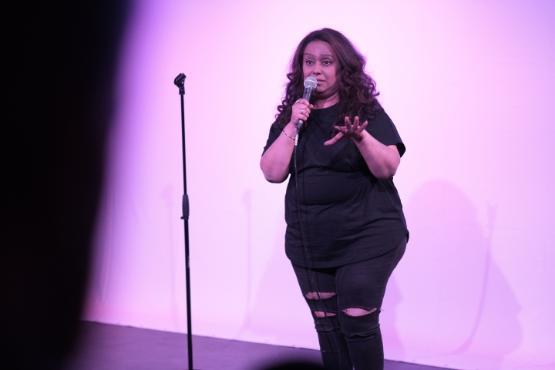 a person holds a microphone in their hand on stage and stand next to a microphone stand a person holds a microphone in their hand on stage and stand next to a microphone stand