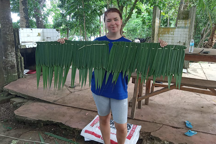 Courtney holding a weaved leaf roof panel. Courtney holding a weaved leaf roof panel.