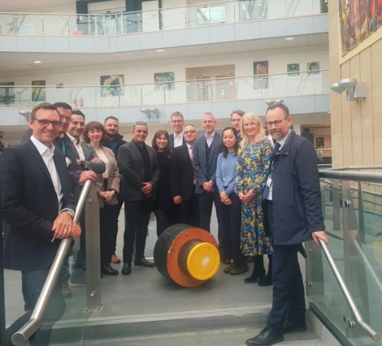 Delegates from 1Energy and the University on campus with a heat pipe Delegates from 1Energy and the University on campus with a heat pipe