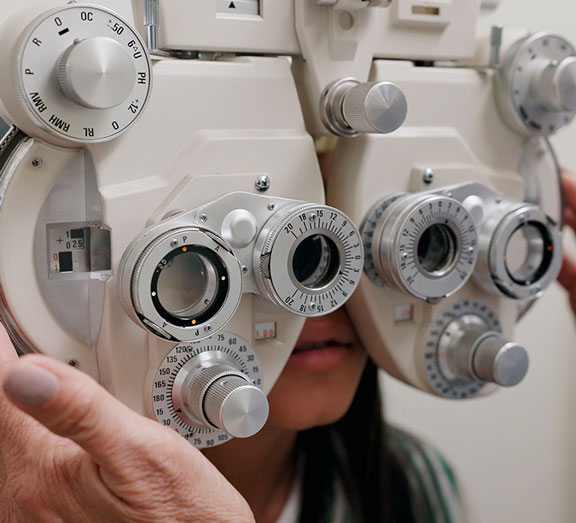 A girl is getting her eyes tested with a piece of opthalmic equipment