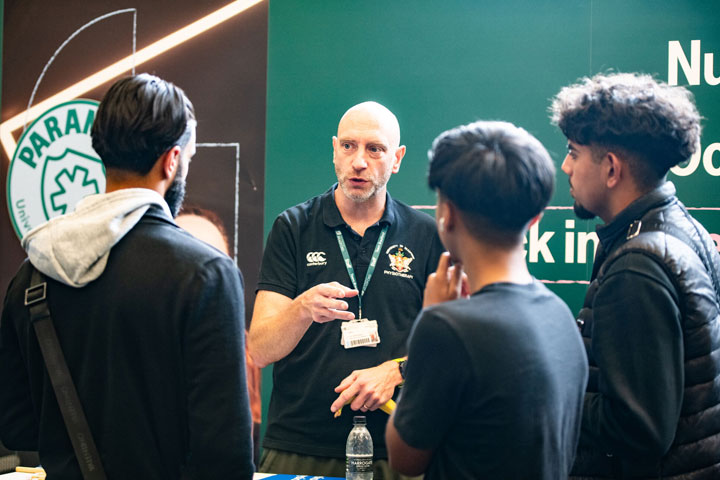A paramedic science lecturer speaking to a small group of students at an Open Day.