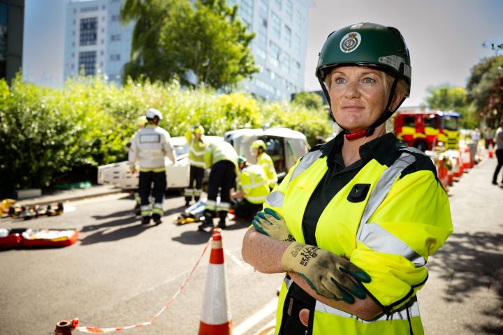 A paramedic student in uniform in front of a crash A paramedic student in uniform in front of a crash