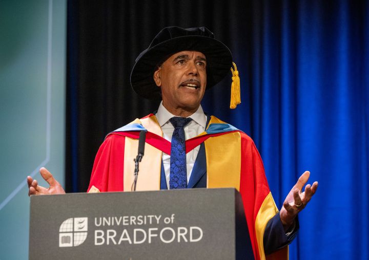 A graduate gives a speech behind a lecturn A graduate gives a speech behind a lecturn