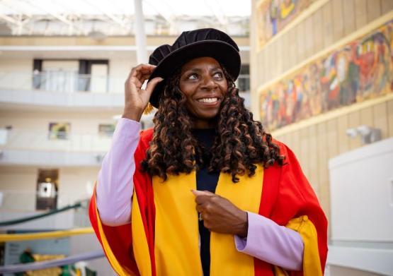person in graduation gown holds onto their graduation cap person in graduation gown holds onto their graduation cap