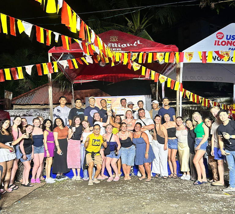 Courtney surrounded by her coursemates in a group photo.