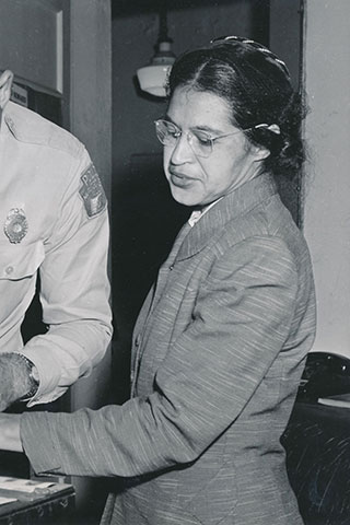 Rosa Parks (civil rights activist) being fingerprinted by a white police officer after her arrest for refusing to give up her bus seat