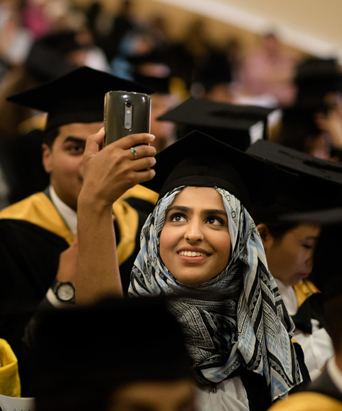 Student taking a selfie at their graduation ceremony.