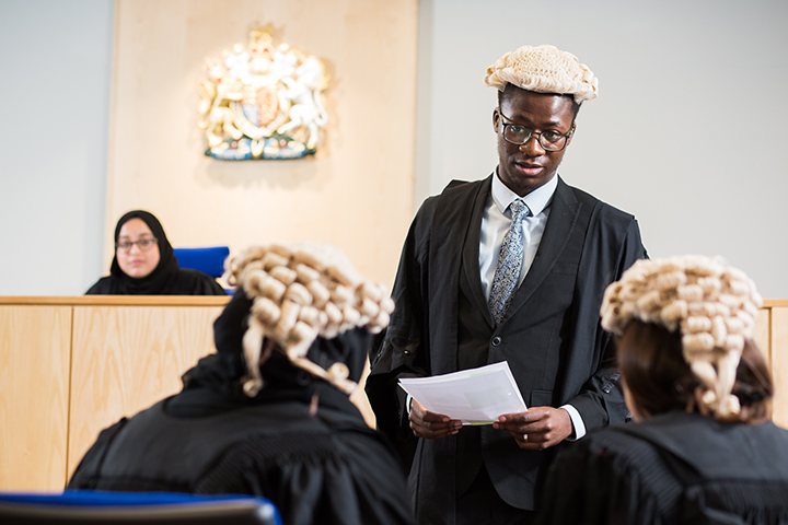 Students wearing legal attire in the mock courtroom