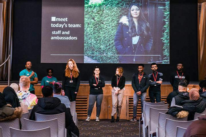 Student ambassadors stood in front of the stage at an Experience Day.