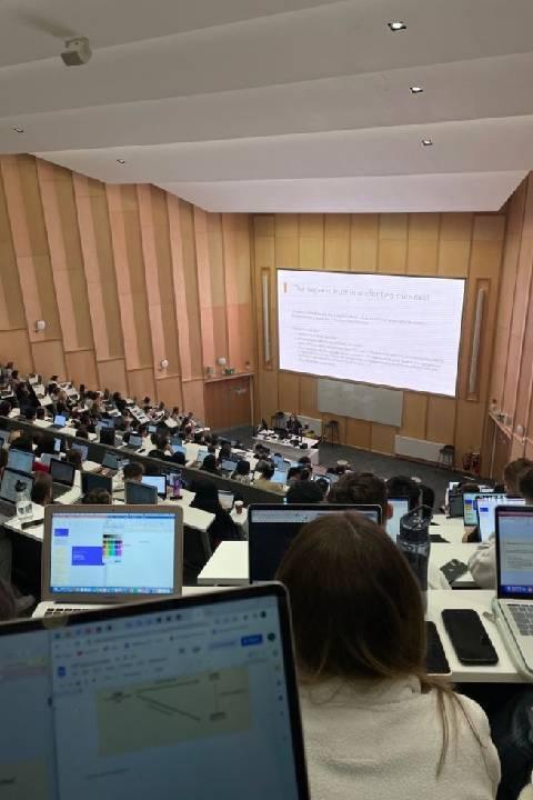 Making the right firm and insurance choice: A view of a University of Bradford lecture hall from high up looking down on lots of students with laptops and a lecturer.