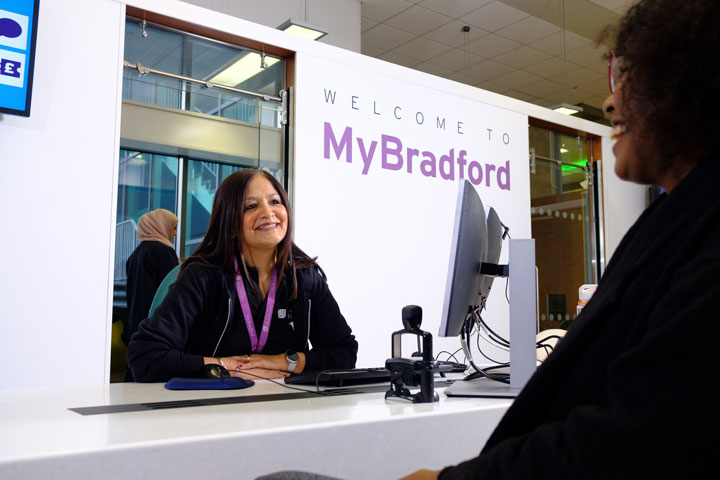 A member of the MyBradford support team chatting and smiling with a student